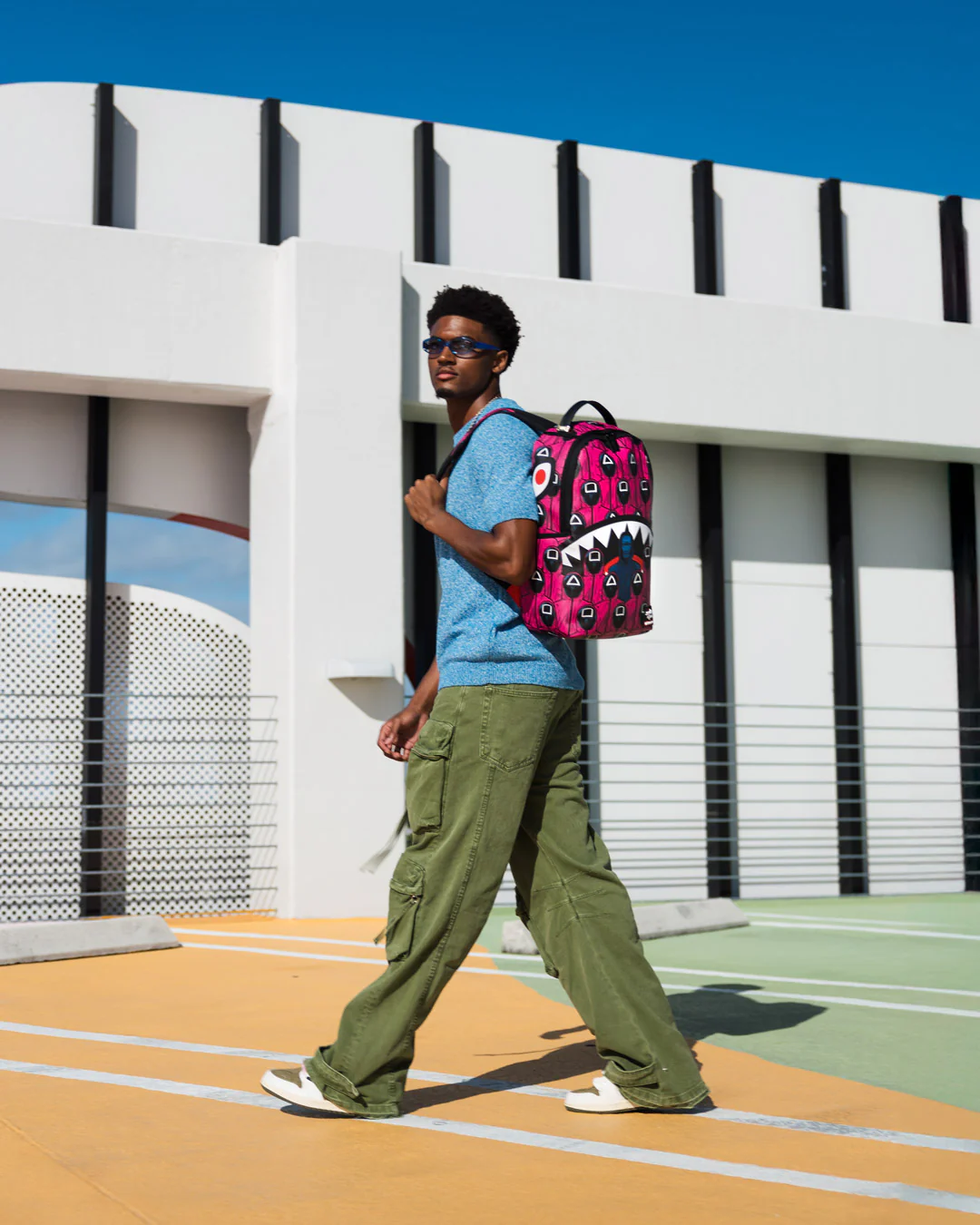 Sprayground X Squid Game Lined Up Front Man & Pink Guard Shark DLXSV Backpack
