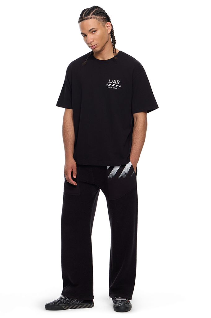 A man modeling a black oversized t-shirt with a small white 'L.A.#color_black