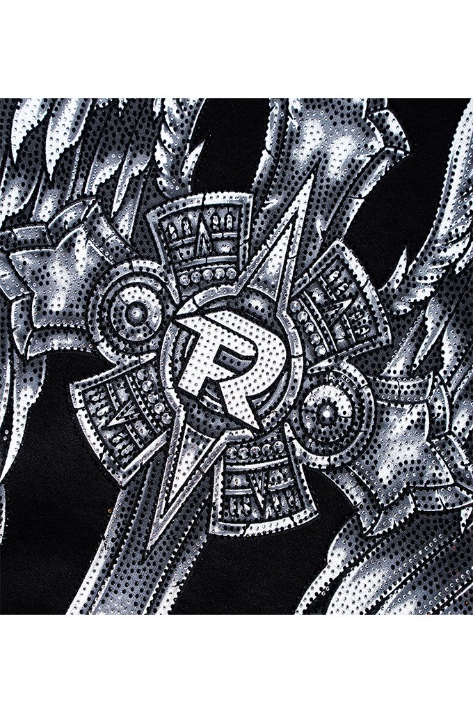A close-up of a black garment featuring a highly detailed, white halftone graphic of a stylized cross with a central letter 'R' and intricate mechanical or tribal-inspired patterns.