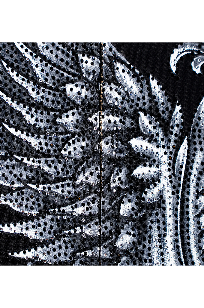 A close-up of a black and white patterned fabric featuring a detailed, textured design of stylized feathers or wings with a dense sequin overlay.