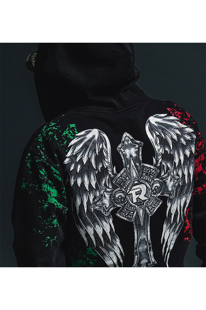 Black hoodie shown from the back, featuring a large white angel wing and cross graphic with a stylized 'R' emblem, plus green and red distressed paint splatter details on the sleeves.