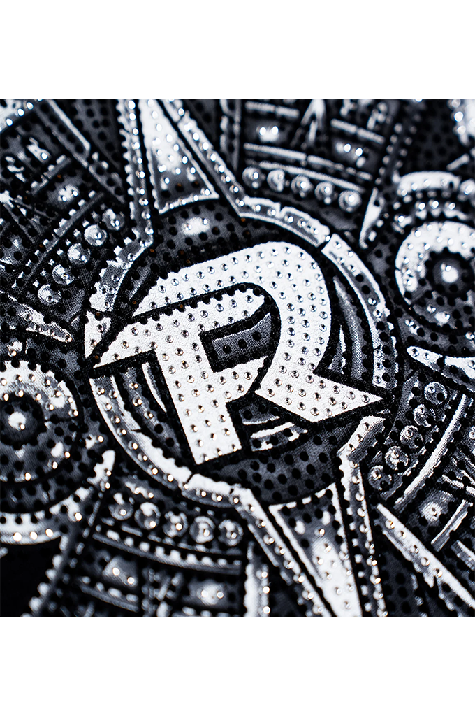 Close up of the letter R with shimmering Rhine stones. 