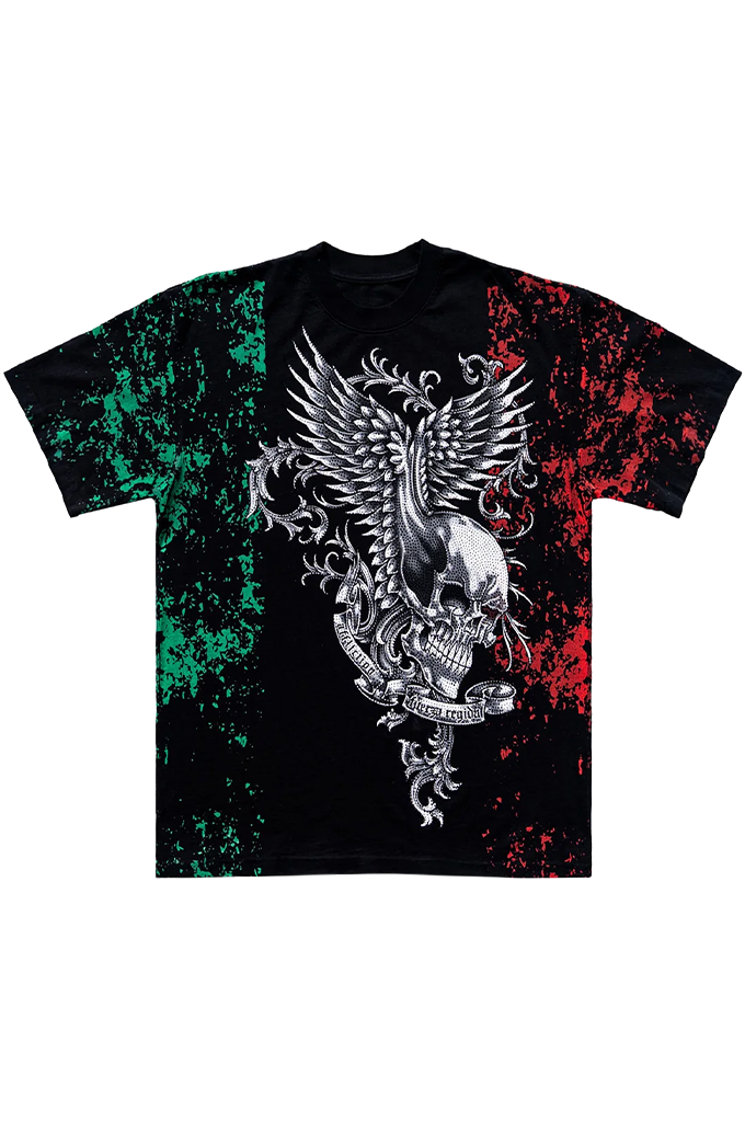 A black short-sleeve t-shirt featuring a large silver metallic eagle and skull graphic on the front, flanked by green splatter patterns on the left and red splatter patterns on the right, resembling the Mexican flag.
