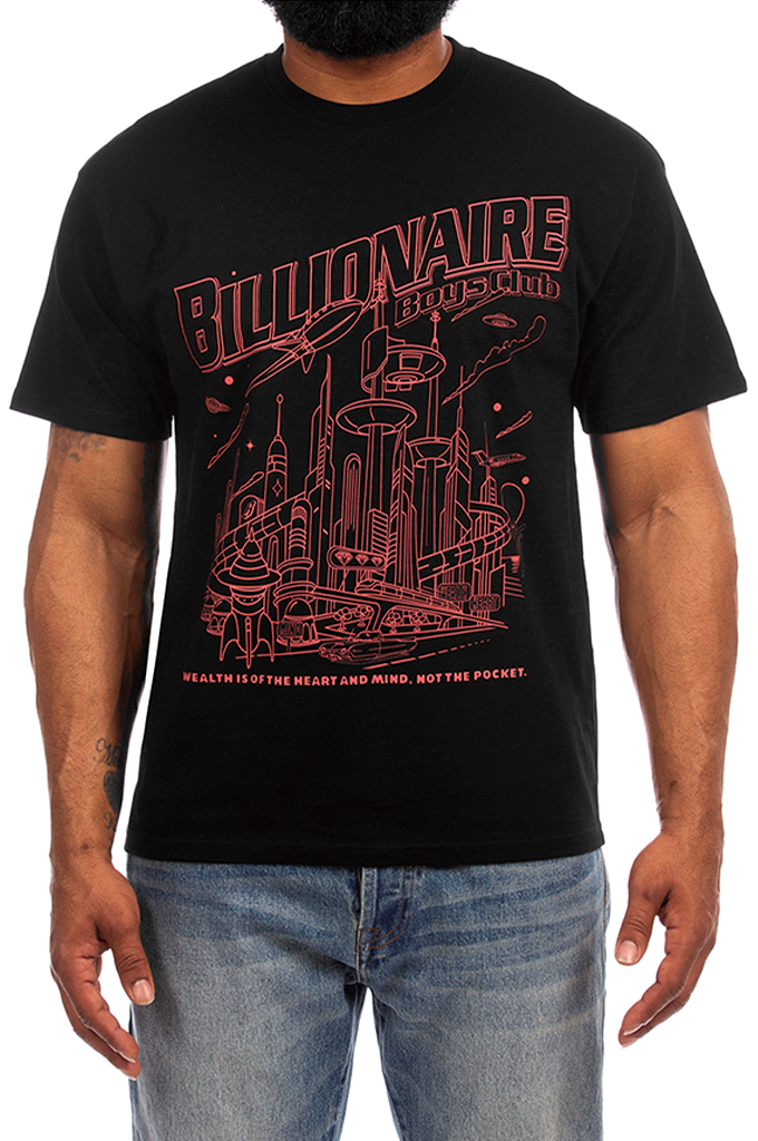 A man wearing a black short-sleeve graphic t-shirt with a red line art design and the text 'BILLIONAIRE BOYS CLUB' on the front, paired with blue jeans against a white background.#color_black