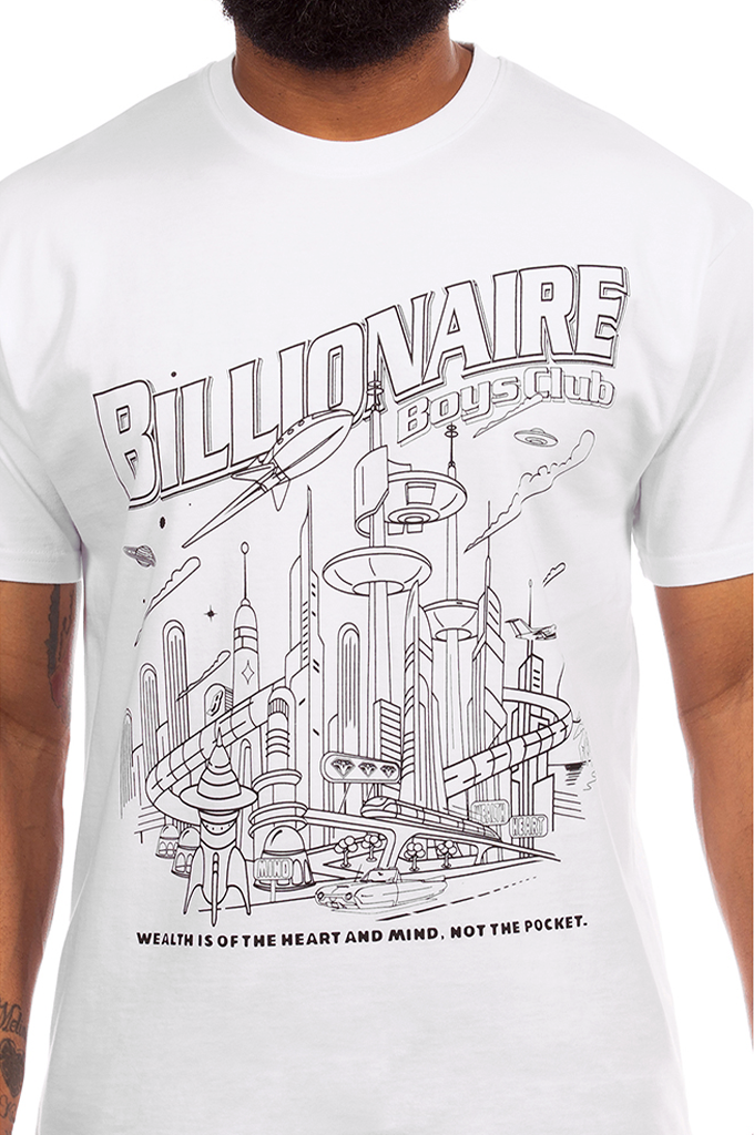 A white short-sleeve crewneck t-shirt featuring a black line art graphic of a futuristic cityscape with the text 'BILLIONAIRE BOYS CLUB' and 'WEALTH IS OF THE HEART AND MIND, NOT THE POCKET.' worn by a model.#color_white