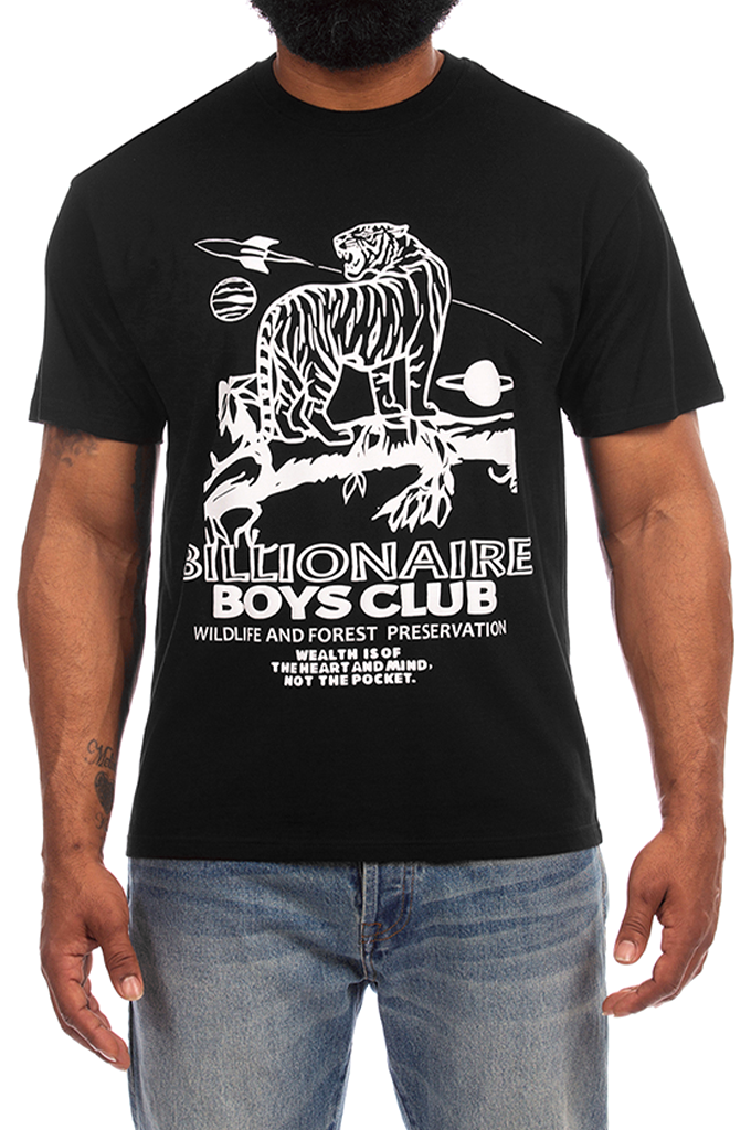 A man wearing a black short-sleeve graphic t-shirt with a white space-themed tiger illustration and the text 'BILLIONAIRE BOYS CLUB WILDLIFE AND FOREST PRESERVATION'.