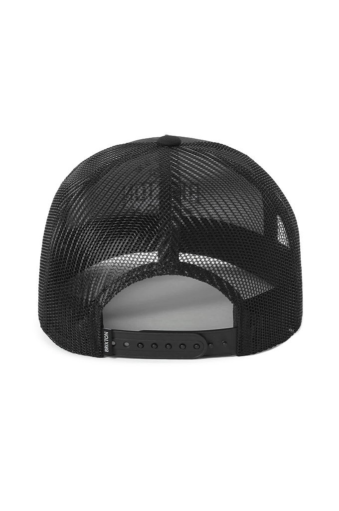 Rear view of a black mesh trucker cap with an adjustable snapback closure, a solid black plastic strap, and a subtle "BRIXTON" brand tag on the left side of the closure.