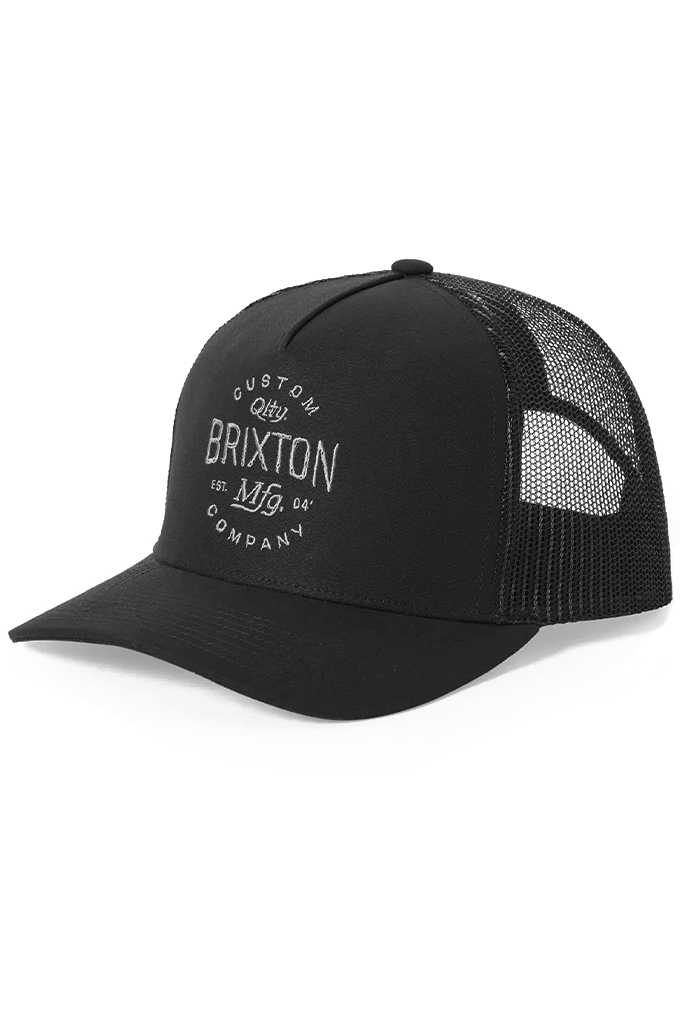 A black 5-panel Brixton Fremont C NP MP trucker hat featuring a curved brim, mesh back panels, and a white circular "Brixton Qlty. Mfg. Company" graphic logo on the structured front.

