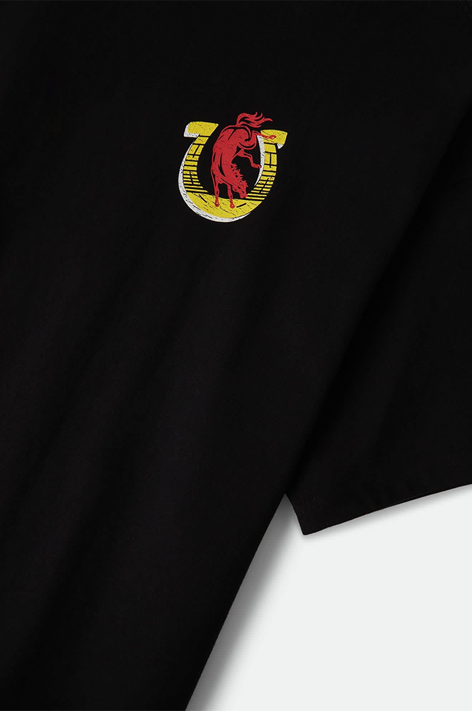 A black t-shirt featuring a small printed graphic on the left chest. The graphic displays a red bucking bull or horse layered over a yellow-and-white horseshoe emblem.