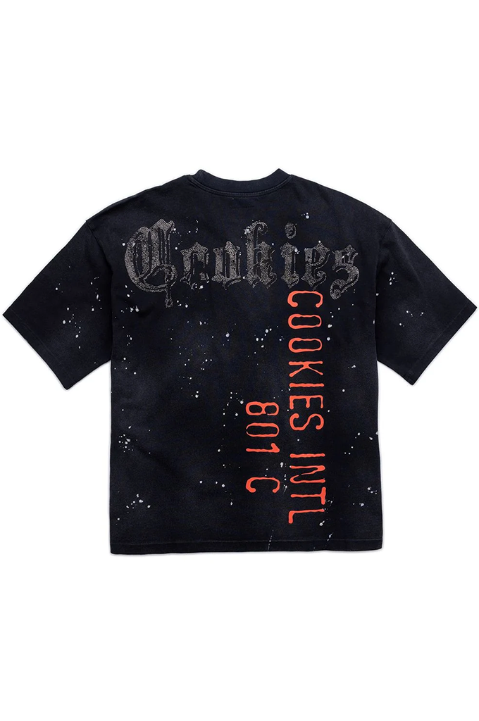 A black short-sleeve t-shirt with a distressed, splattered design, featuring 'Cookies Intl' in a gothic font across the chest and 'COOKIES INTL 801 C' printed vertically in red on the back.