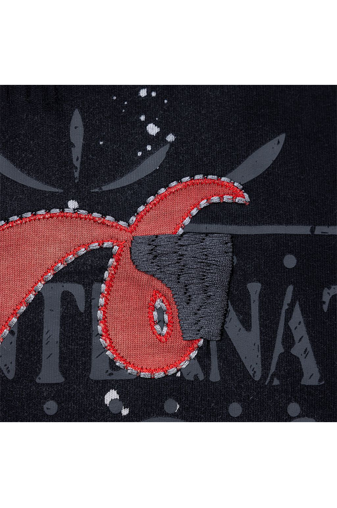 Close-up of a dark navy knit fabric featuring a red and gray embroidered patch design with white stitched border details.