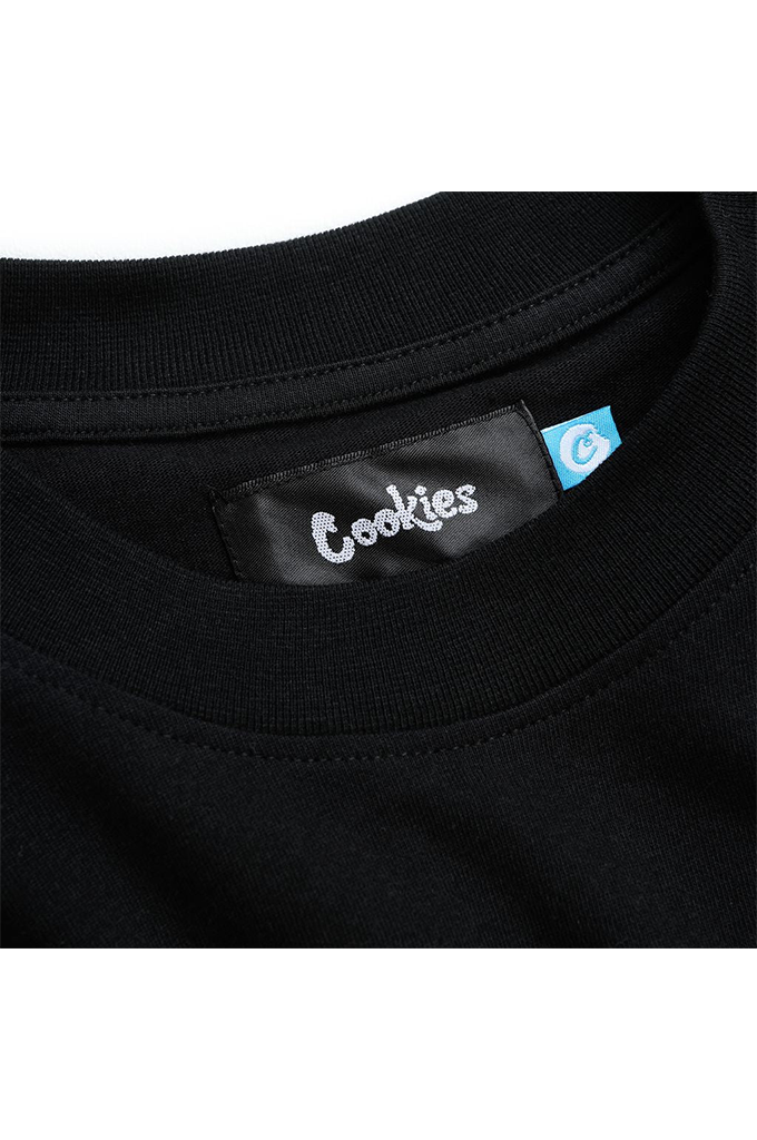 Close-up of a black tee showing the inner neck label with 'Cookies' written in white script and a small blue tag.