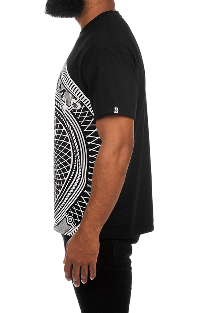 Side profile of a man wearing a black short-sleeve t-shirt with a large white geometric tribal-style graphic print on the front panel, set against a plain white background.#color_black