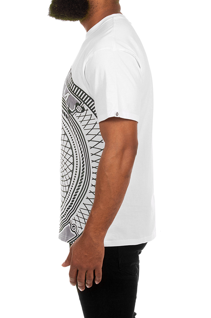 A man shown from the side wearing a white short-sleeve t-shirt with a black tribal geometric pattern printed on the front, paired with black pants, against a plain white background.#color_white