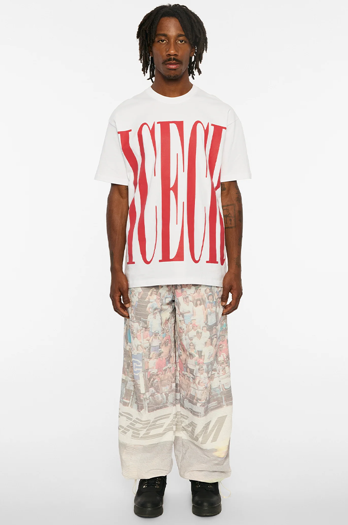 Model wearing a white ICECREAM Chai short sleeve graphic t-shirt by Billionaire Boys Club paired with oversized printed pants. #color_white