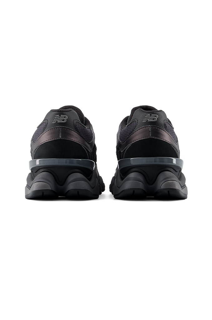 Back view of a New Balance 9060 sneaker in a black and grey colorway, featuring its signature chunky, sculpted midsole.#color_black-grey-castlerock
