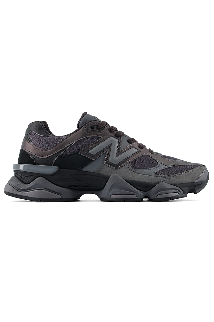 Profile view of a New Balance 9060 sneaker in a black and grey colorway, featuring its signature chunky, sculpted midsole. #color_black-grey-castlerock