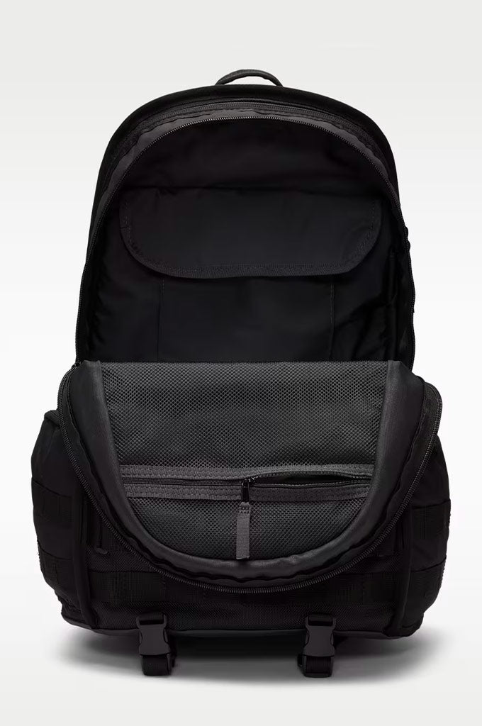 A black backpack shown open against a light gray studio background, displaying its interior compartments, mesh pocket, and front zippered compartment.#color_black