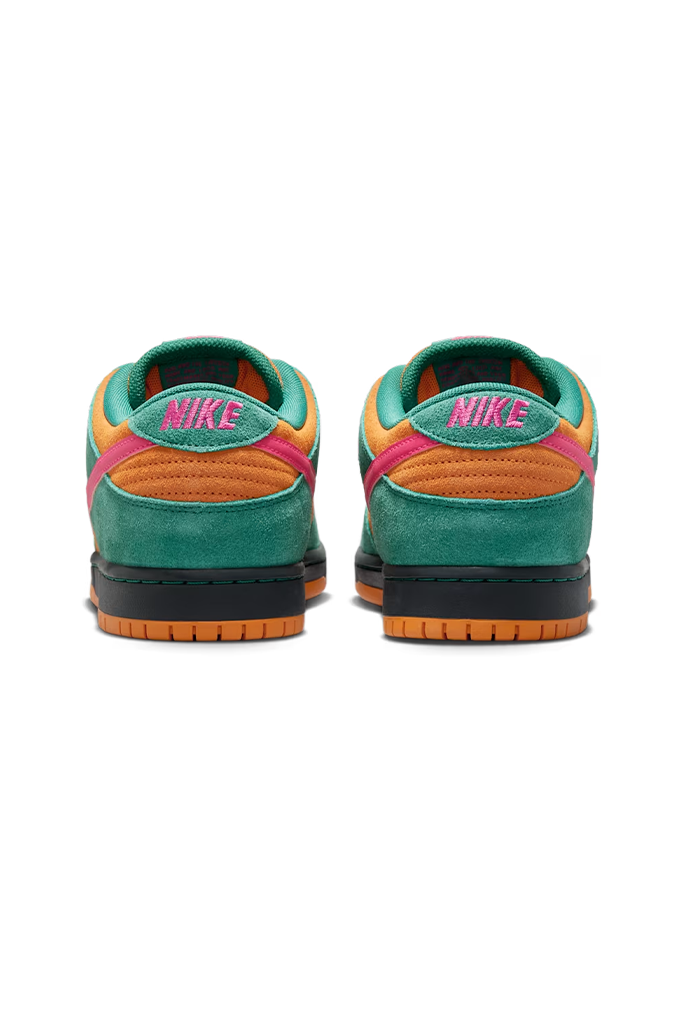 A pair of Nike low-top sneakers shown from the back, featuring teal green suede overlays, orange suede panels, a pink embroidered Nike logo on the heel, and a black and orange sole.
