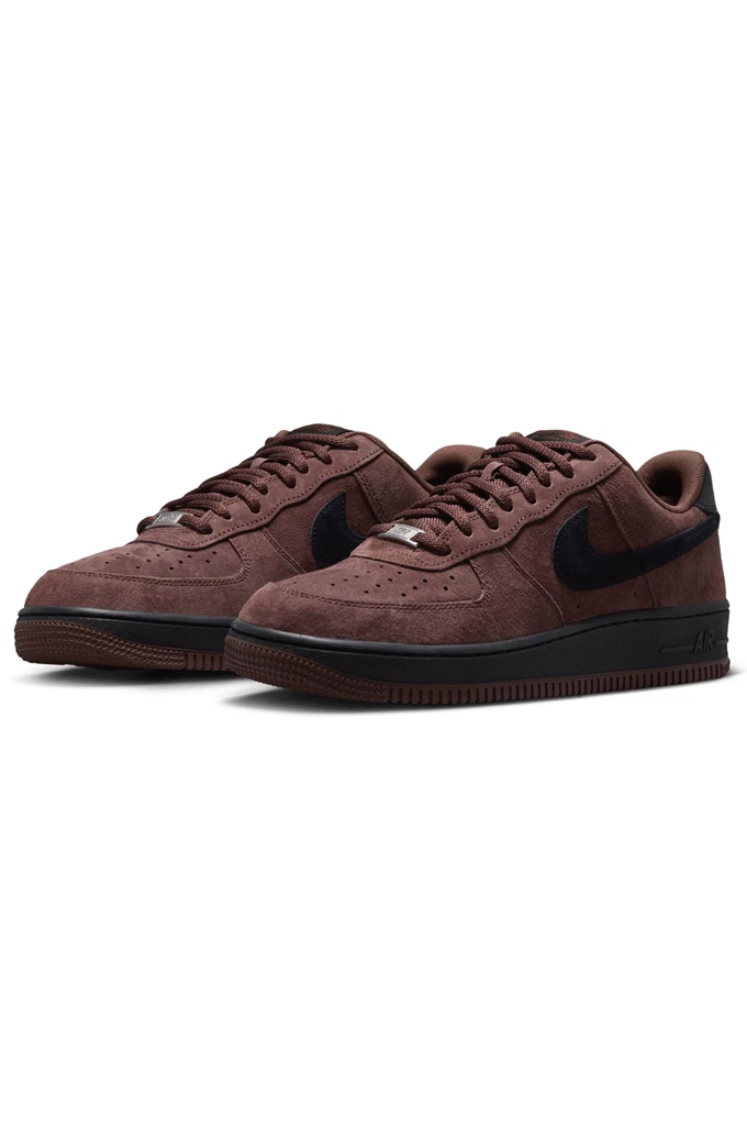 A pair of Nike Air Force 1 Low sneakers in a dark brown suede and black leather combination, shown from a three-quarters angle on a plain white background.