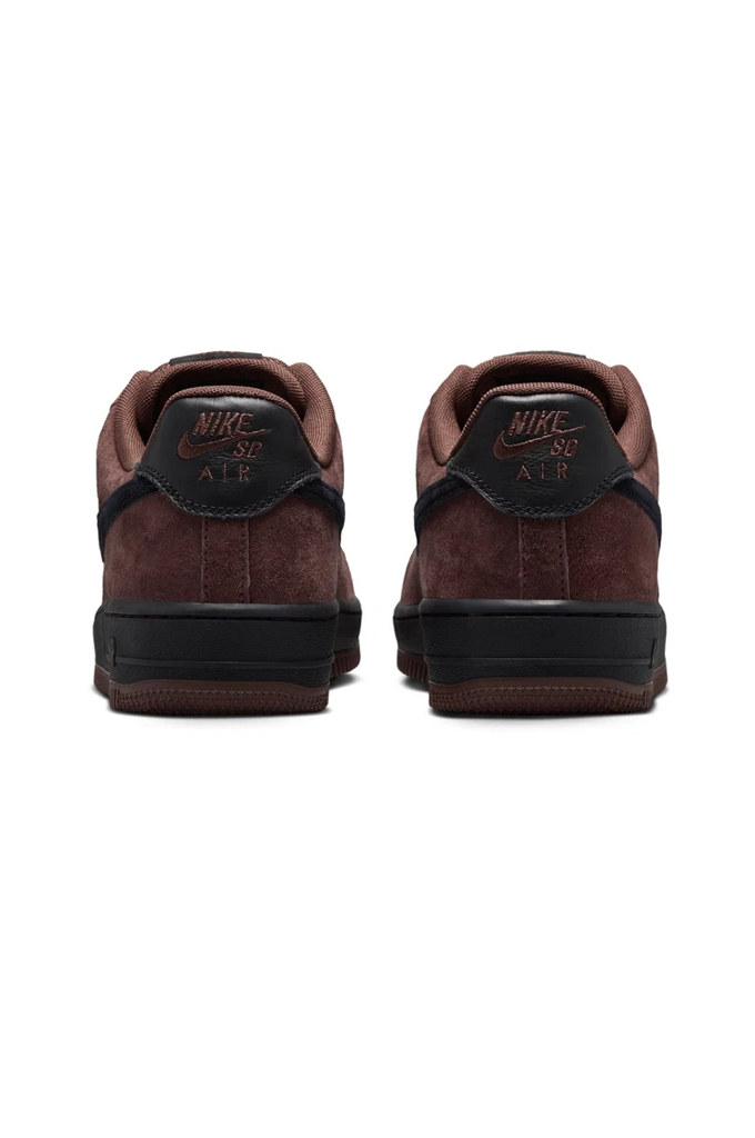 A pair of Nike SD Air low-top sneakers shown from the back, featuring dark brown suede and black leather overlays with gold branding.