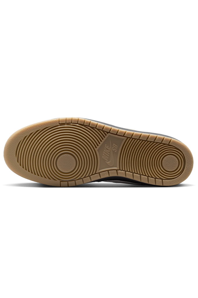 The gum rubber outsole of a Nike shoe, showing the circular tread pattern and embossed Nike Swoosh logo, photographed from a top-down view on a white background.