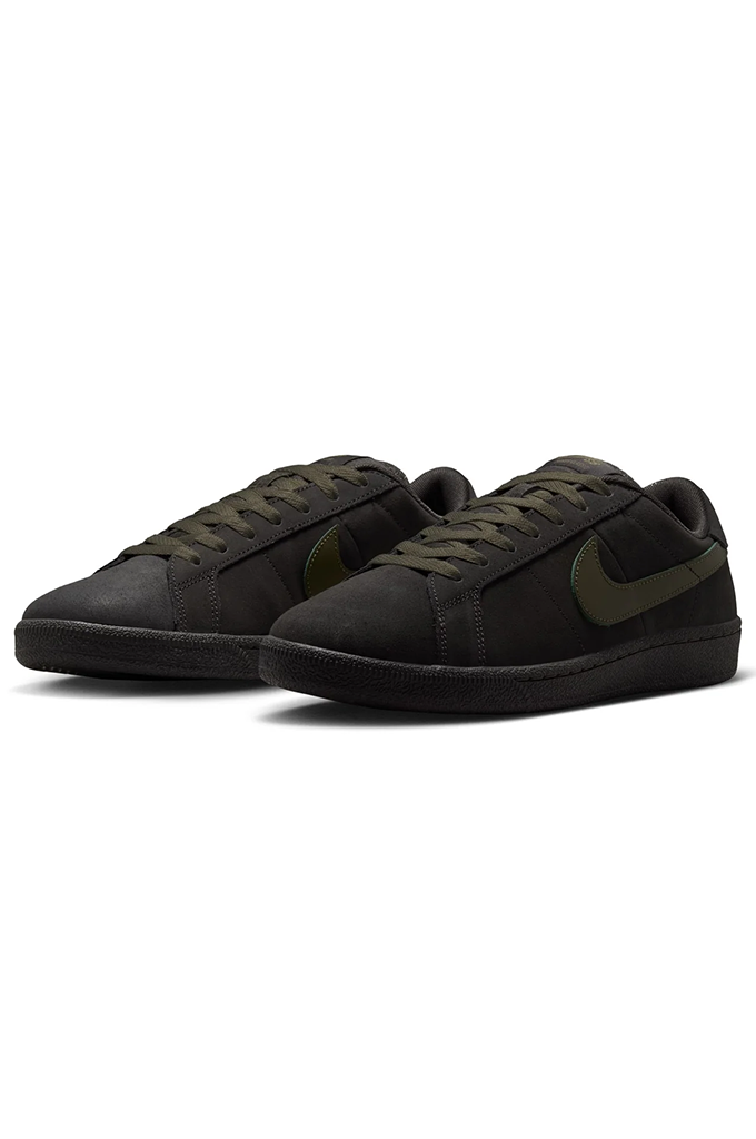 Side of Grey Nike SB shoe with olive green swoosh on a white background. 