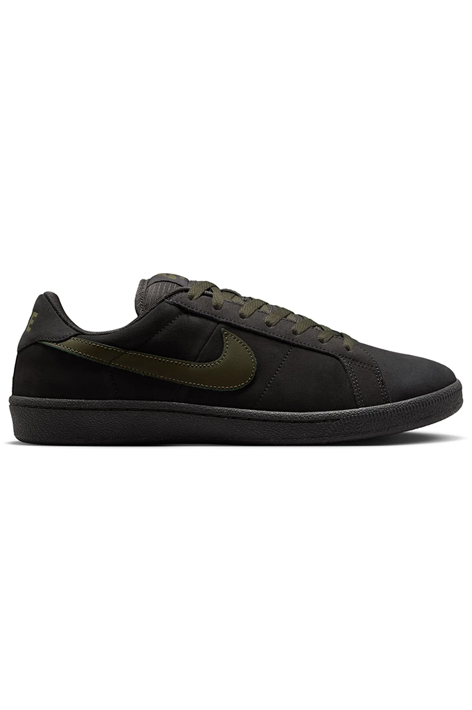 Side of Grey Nike SB shoe with olive green swoosh on a white background. 