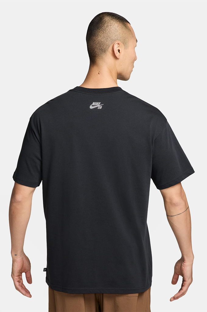 A man viewed from the back wearing a black Nike t-shirt with a small white Nike Swoosh logo on the upper back, paired with brown pants, against a light gray studio background.#color_black