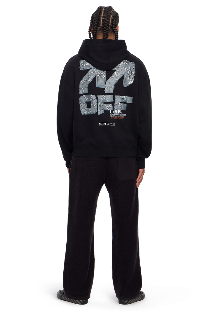 A person shown from the back wearing a black hoodie and black sweatpants. The hoodie features a large silver and white graphic on the back reading '777 OFF' with a small 'Vans' logo below it.#color_black