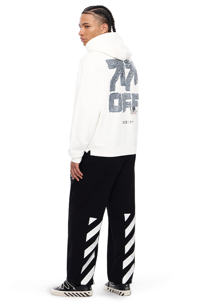 A model shown from the back wearing a white hoodie with a large gray graphic print on the back, paired with black sweatpants featuring white diagonal stripes down the sides, and black and white sneakers.#color_white