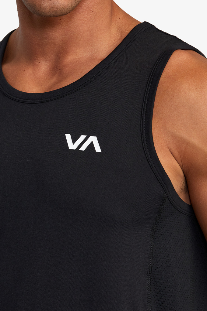 Close-up of a man wearing a black athletic tank top with a white 'VA' logo on the chest, showing the shoulder and torso against a light background.