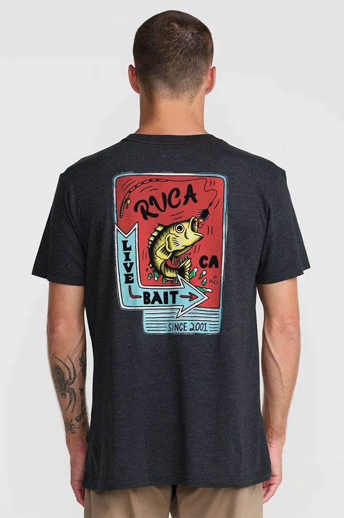 A man viewed from the back wearing a dark charcoal heather t-shirt with a large graphic print on the back. The graphic features a red background, a yellow bass fish, and blue and white text reading 'RVCA LIVE BAIT' and 'CA SINCE 2015'.#color_black