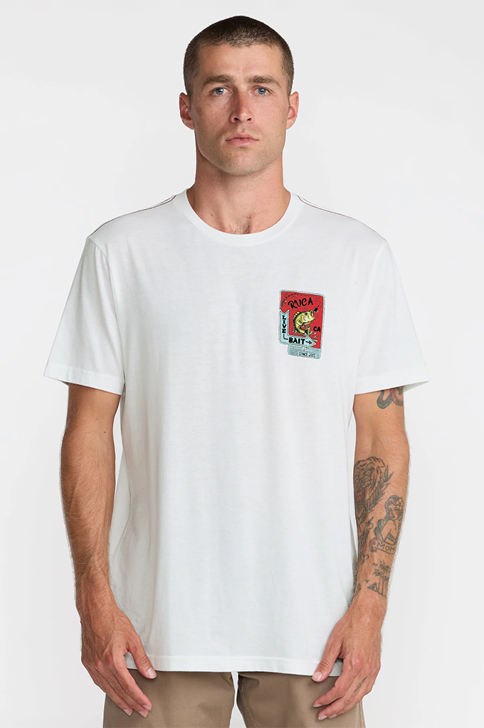 A man wearing a white short-sleeve crewneck t-shirt with a colorful graphic print on the left chest, paired with khaki pants, against a plain light gray background.#color_antique-white