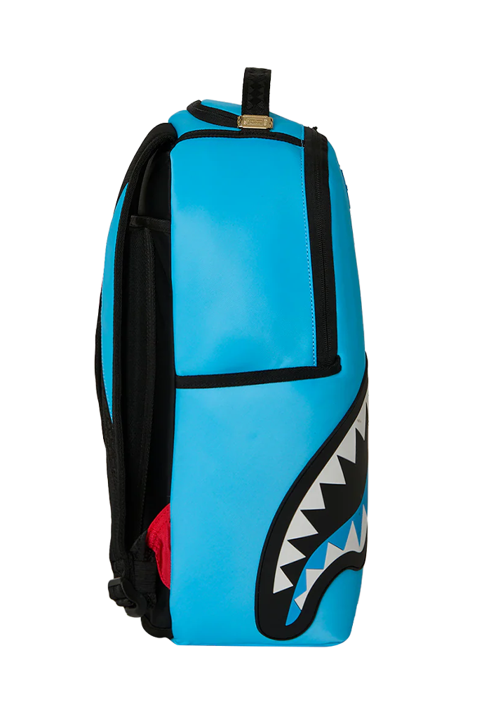 A bright blue backpack featuring a black shark mouth graphic with white teeth on the lower right side, shown against a plain white background.