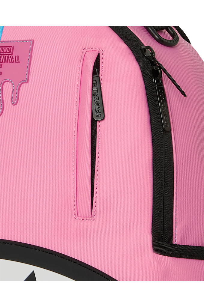 Close-up of a pink backpack with black zipper details, a vertical zippered pocket, and a pink hangtag on the upper left.