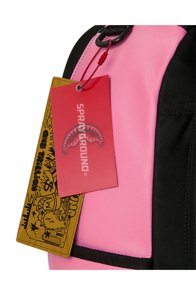 Close-up of a pink and black backpack with a red and yellow Sprayground 'One Trillion' hangtag attached, on a white background.