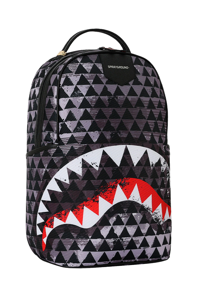A Sprayground backpack featuring a black and gray geometric triangle pattern with a large shark mouth graphic in red, white, and black on the lower front.