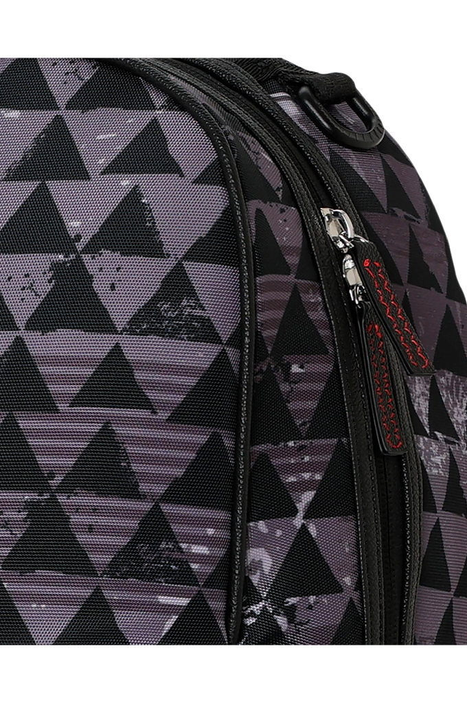 Close-up of a backpack featuring a geometric triangle pattern in black and dark gray with a textured, distressed finish. A silver zipper with a red and black pull tab is visible on the right side.