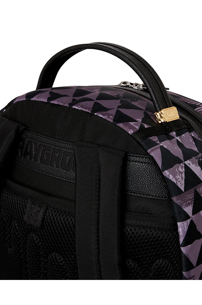 Close-up of a black and purple geometric patterned backpack with a top handle, black mesh pocket, and a gold zipper pull on a white background.