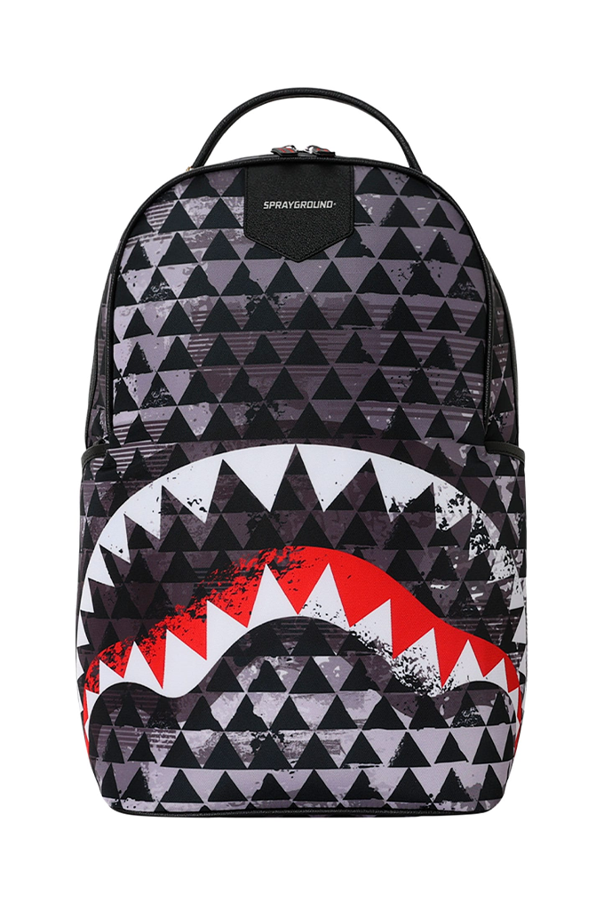 A Sprayground backpack featuring a black and white geometric triangle pattern with a large shark mouth graphic in red, white, and black across the lower half.