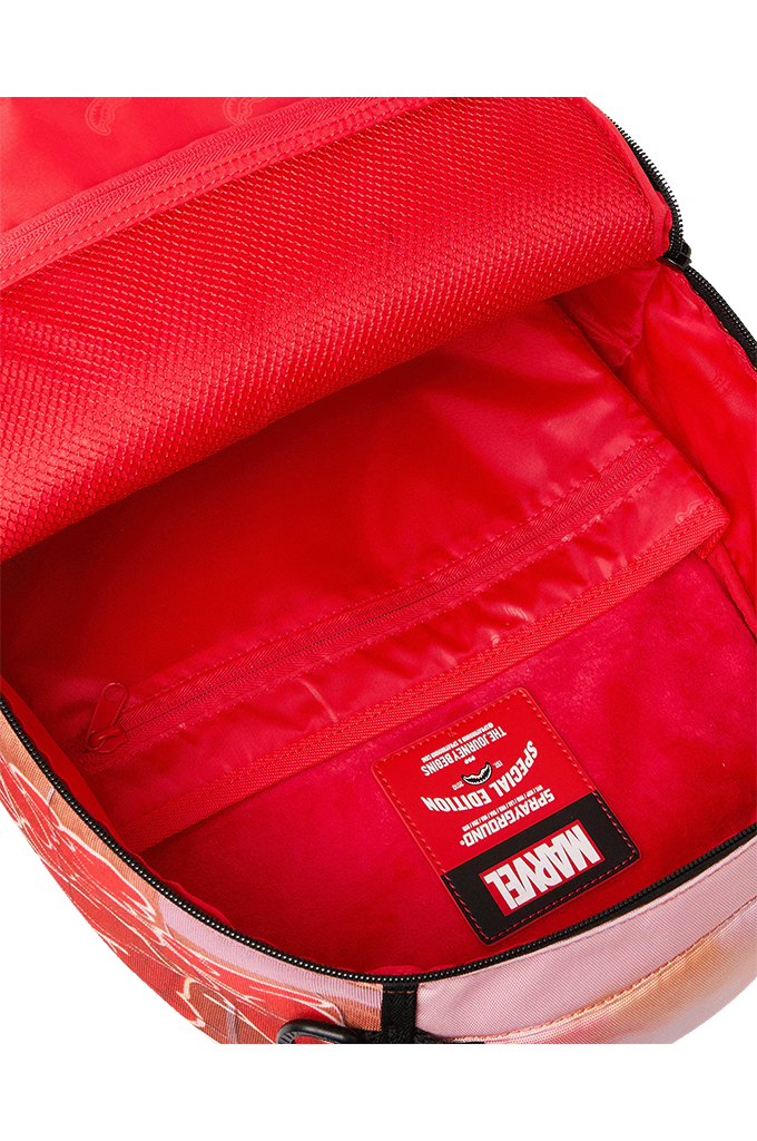 Close-up of the interior of a Marvel backpack, showing a bright red nylon lining with a black Marvel logo patch on the bottom right and a zippered compartment.