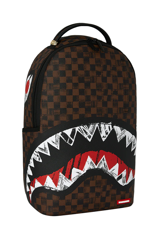 A brown and black checkered backpack featuring a large shark mouth graphic on the front with white, red, and black details, shown against a plain white background.