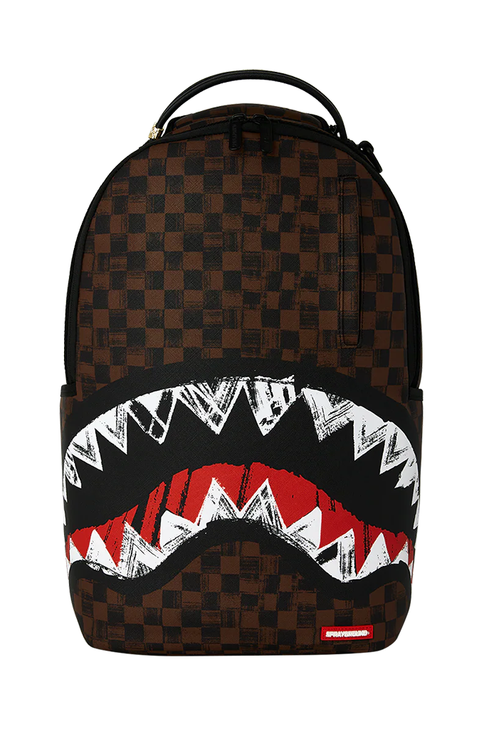 A Sprayground Shark backpack featuring a brown checkerboard pattern, a large shark mouth graphic with white teeth and a red interior on the lower front, and a top carry handle.