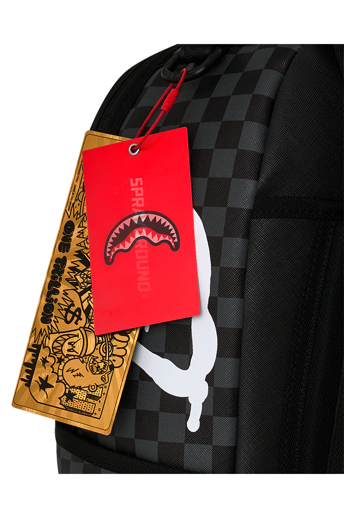 A close-up of a black and gray checkered backpack with a red hangtag featuring a shark mouth logo and the brand name SPRAYGROUND, alongside a tan leather hangtag with graphic artwork.