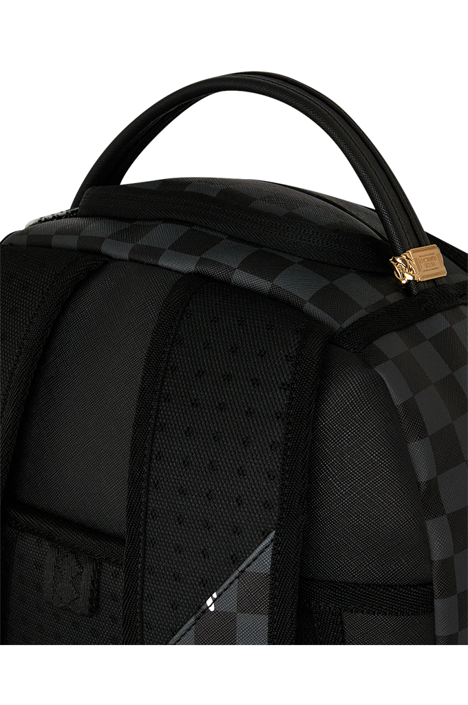 Close-up of a black backpack featuring a checkerboard pattern, a top carry handle, and a small gold-toned lock on a white background.
