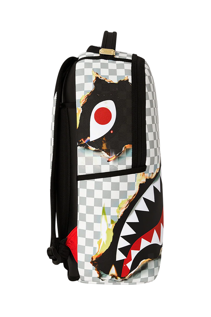 A backpack featuring a black and white checkerboard pattern with a large shark-face graphic on the front, including red and yellow details, photographed against a plain white background.