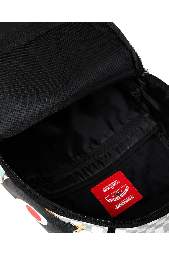 Close-up of the interior of a black backpack, showing a zippered compartment with a red rectangular brand patch on the black fabric lining.