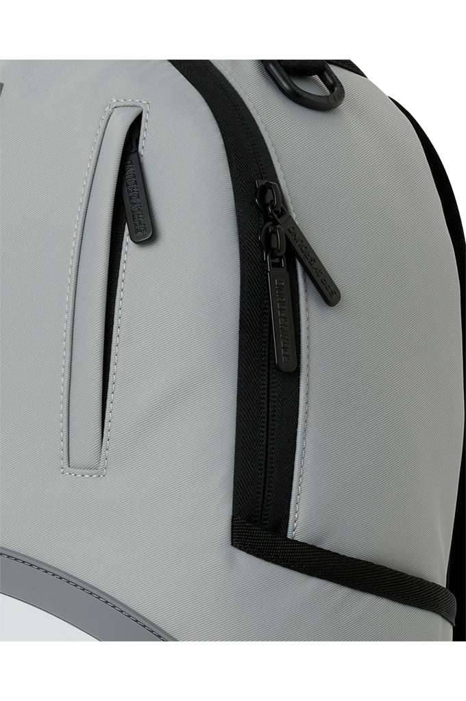 Close-up of a light gray backpack showing a vertical zippered pocket with a black zipper pull and black trim.
