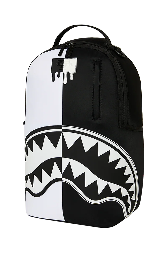 A black and white backpack featuring a split design with a dripping paint motif on the top and a large shark mouth graphic across the lower half, shown against a plain white background.